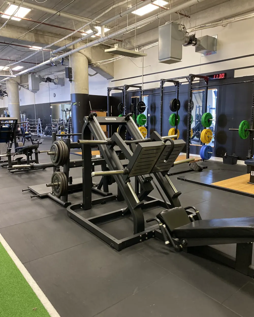 45-degree leg press and power racks with colour-coded plates at Compound Gym