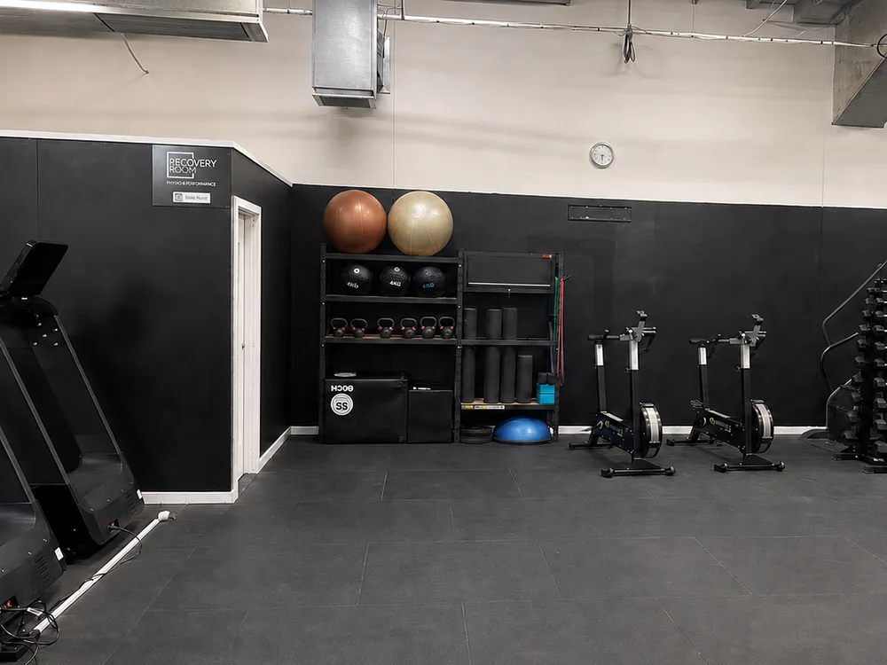 The warm-up zone at Compound Gym: treadmills, erg bikes, swiss balls, medicine balls, kettlebells and foam rollers